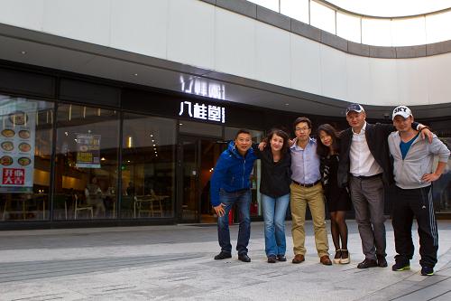 張高山（右二）和他的創業團隊成員在位於北京望京SOHO的一家名為“八桂堂”的桂林米粉店前合影（10月3日攝）。這是一家由31名廣西老鄉眾籌投資、共同經營的桂林米粉店，9月28日開張迎客當天賣出了500碗米粉，且供不應求。