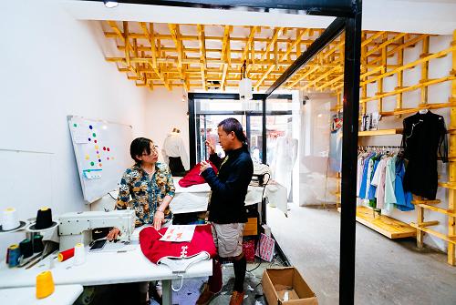 扎西（右）在拉薩的工作室將剛剛繪製好的服裝設計草圖和布料交給裁縫製作，並叮囑剪裁注意事項（8月12日攝）。“怡嗡”是一個生根于拉薩的時裝品牌，服裝設計帶有濃濃的藏式風情。它的創辦人，是一名年僅32歲的藏族小夥子——根確扎西。根確扎西來自四川甘孜，2006年從煙臺師範學院畢業後開始闖蕩打拼，2011年來到拉薩。2012年，扎西創立了自己的服裝品牌“怡嗡”並舉辦時裝發佈會，開始了他在拉薩的創業征途。“怡嗡”的成長之路並非坦途，但扎西從未忘記他的夢想——創造一個時尚品牌，從西藏走向全國乃至世界。而他的堅持也有了收穫：“怡嗡”服裝目前不僅亮相國內市場，還遠銷尼泊爾、印度和歐洲。