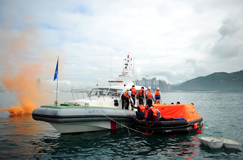 1月29日，在海南三亞市情人灣海域進行的旅遊船海上棄船演習中，“船員”登上救援船隻。