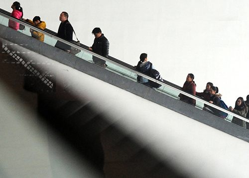 2月13日，準備出行的旅客乘坐電梯進入蘇州火車站候車大廳。
