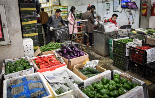 2月16日，工人在深圳海吉星批發市場搬運蔬菜。新華社記者 毛思倩 攝