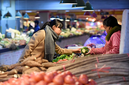 2月18日，市民在鄭州市緯四路菜市選購蔬菜。
