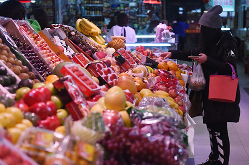 2月18日，市民在長春市一家農貿市場內挑選水果。