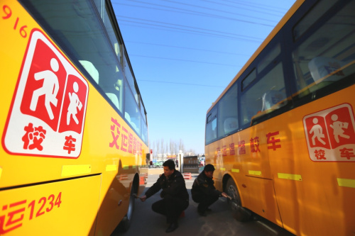 2月18日，山東青島交運集團即墨分公司的技術人員在檢查校車的安全狀況。新華社發（梁孝鵬 攝）