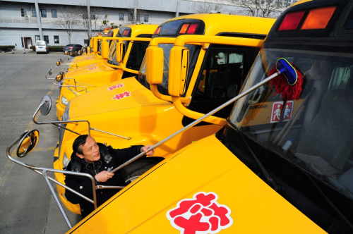 2月18日，江蘇省太倉市校車駕駛員在擦拭校車前擋風玻璃。新華社發（計海新 攝）