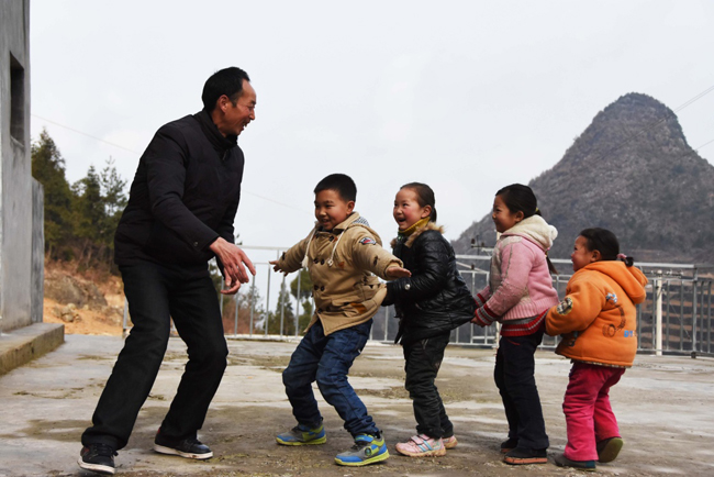 2月24日，陶朝雷老師與孩子們在課間做遊戲。坐落在重慶市巫山縣騾坪鎮的蘇家村小學，是一所位於海拔1000余米山區的“微小學”。學校裏只有一位老師和四名學生。2月24日是學校開學的日子，現年52歲的陶朝雷老師帶著一名三年級學生和三名學前班的孩子開始了新的學期。
