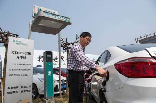 3月18日，一名車主在重慶市內一處停車場使用國網重慶市電力公司的充電樁為新能源電動汽車充電。新華社記者 劉潺 攝