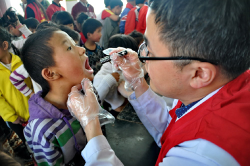 4月9日，醫務志願者在為留守兒童檢查口腔。