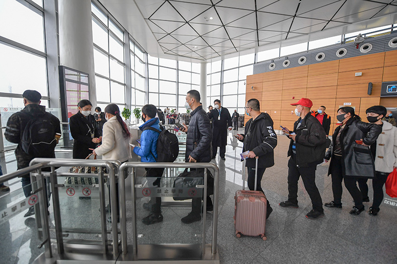2月21日,在长春龙嘉国际机场,务工人员排队验票登机.