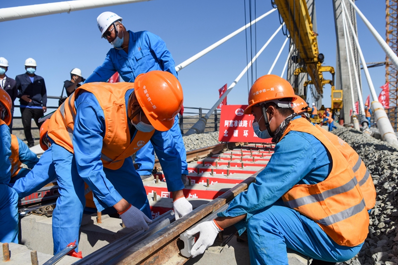 7月2日,中铁一局的施工人员在阿富准铁路阿勒泰至富蕴段进行铺轨作业.